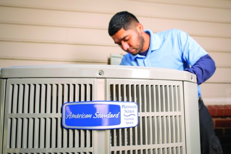 AC Technician Installing American Standard Condenser